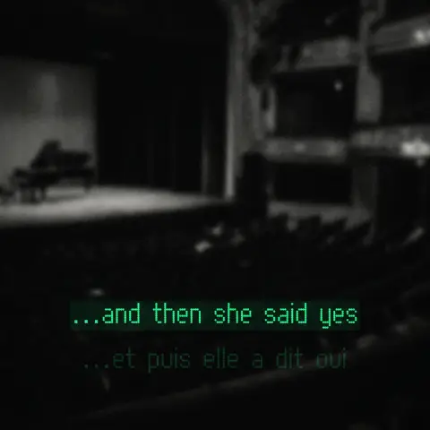 Green caption lines over a dark theater